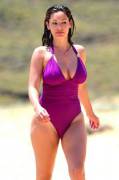 Kelly Brook straining her purple one-piece swimsuit