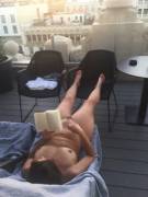 Nudist wife reading on rooftop