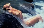 Ursula Andress laying on a waterfall.