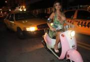 Topless on a Pink Vespa in traffic.
