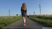 Young Girl Walking Barefoot On The Road