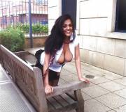 Flashing her boobs while kneeling on a bench