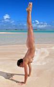 Naked handstand on the beach