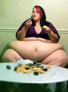Huge girl eating snacks rests arms on sezy tummy