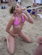 Funneling a beer on the beach with her tits out and her hand in her bottoms.