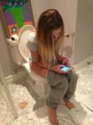 On her phone while going potty