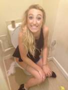 Smiling Peeing Blonde on the Toilet