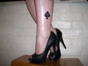 Black heels and a black QoS tattoo