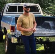 Bearded stud leaning on his truck