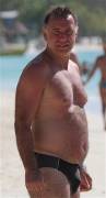 Slightly chubby daddy in a speedo on the beach