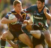 Brent Tate of the Brisbane Broncos is tackled by two Penrith Panthers players (Sydney, Mar. 16, 2003. Photographed by Chris McGrath)