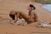 Two naked wild women playing in the mud