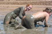 Park visitors photograph two beautiful women taking a mud bath like all the other animals in the reserve