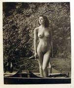 Nude women floating in a boat.