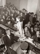 A stripper at a Tokyo striptease show is taken past the audience on a moving conveyor belt, 1957.