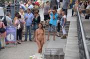 This cute Asian's reaction is priceless, as she relishes the attention her nudity is giving her in a crowded tourist area in Berlin, Germany