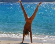 Naked handstand on the beach