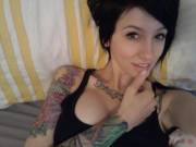Tattooed girl taking a selfie from lying down position, she has set the standard for all future selfies