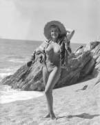 From Kamera Klub we have Nancy Roberts posing on a beach with only a sun hat and beach towel for shade. From a photographic glass plate and was taken in September, 1959 at the beach near Sheplegh Court, Devon, England.