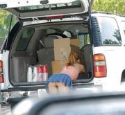 Loading her groceries into the vehicle