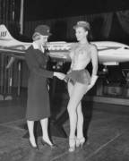 Swedish stewardess Birgitta Lindman with the Swedish SAS airline examines a showgirls costume after rumors of shorter skirts for air hostesses. Jan. 12, 1959.