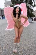 Micaela Schaefer almost naked wearing Christmas angel costume at the Brandenburg gate in Berlin.