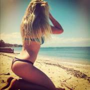 Blonde kneeling on the beach