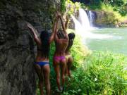 Blue, Red, Yellow with hands up by waterfall