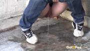 A big wet puddle appears as this sexy babe in denims pisses onto concrete