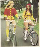 A couple of foxy ladies ride their bikes in the '70s.