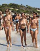 Topless girls walking on a crowded beach