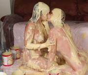 Girls covered in custard kissing each other 