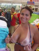 Beauty flashing her big tits in a busy store