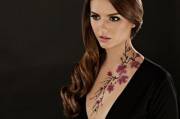 Beautiful brunette with flowers on her neck.