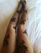Black floral pantyhose on long legs.