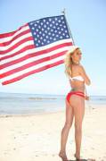 Spreading freedom at the beach with her majestic flag (x-post /r/FlagBabes)